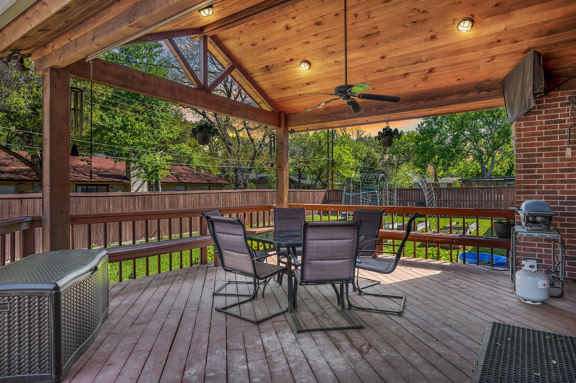 A kitchen with white cabinets , wooden floors , stools and a large island.