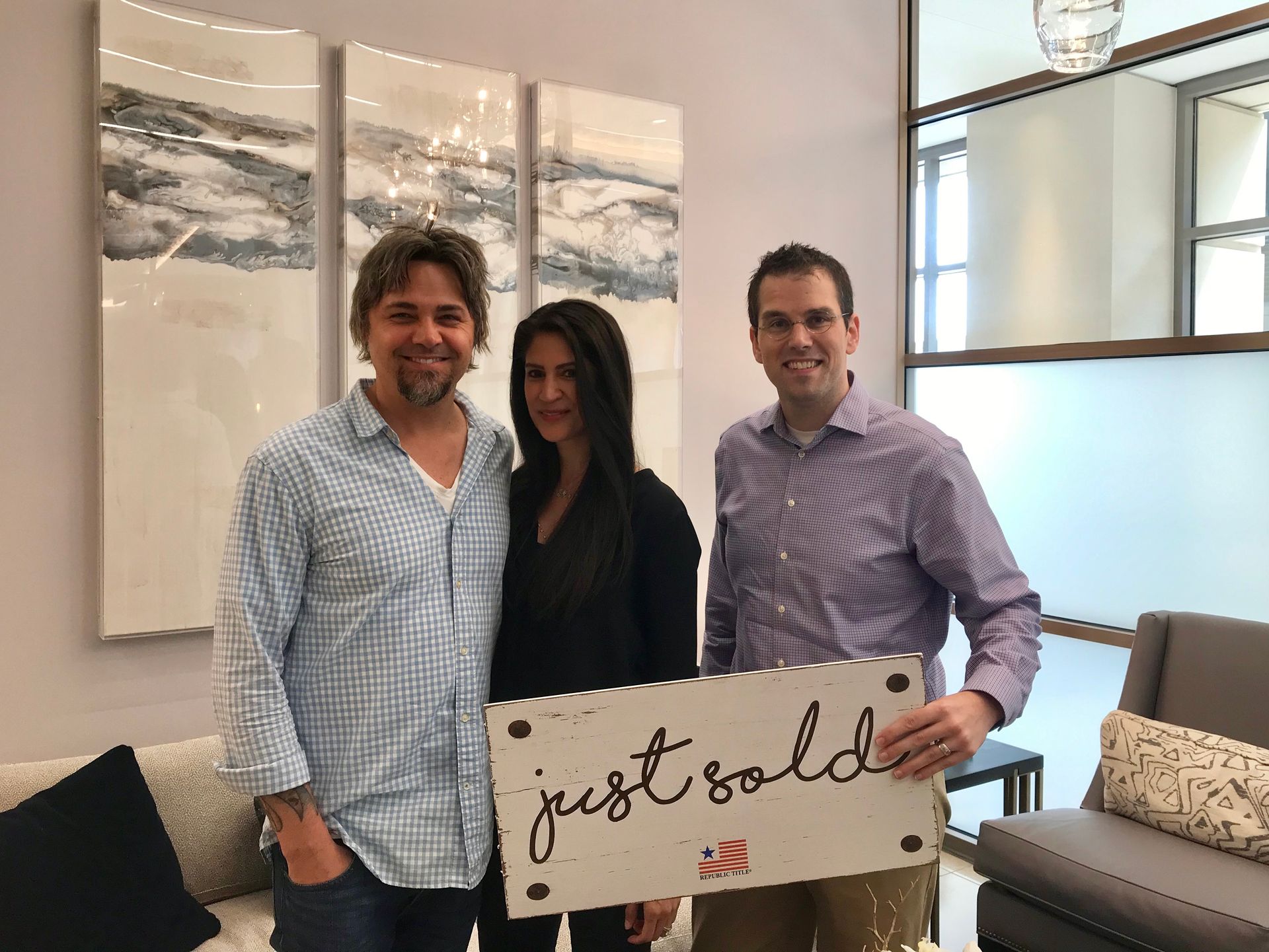 A little girl is carrying a cardboard box in front of a family.