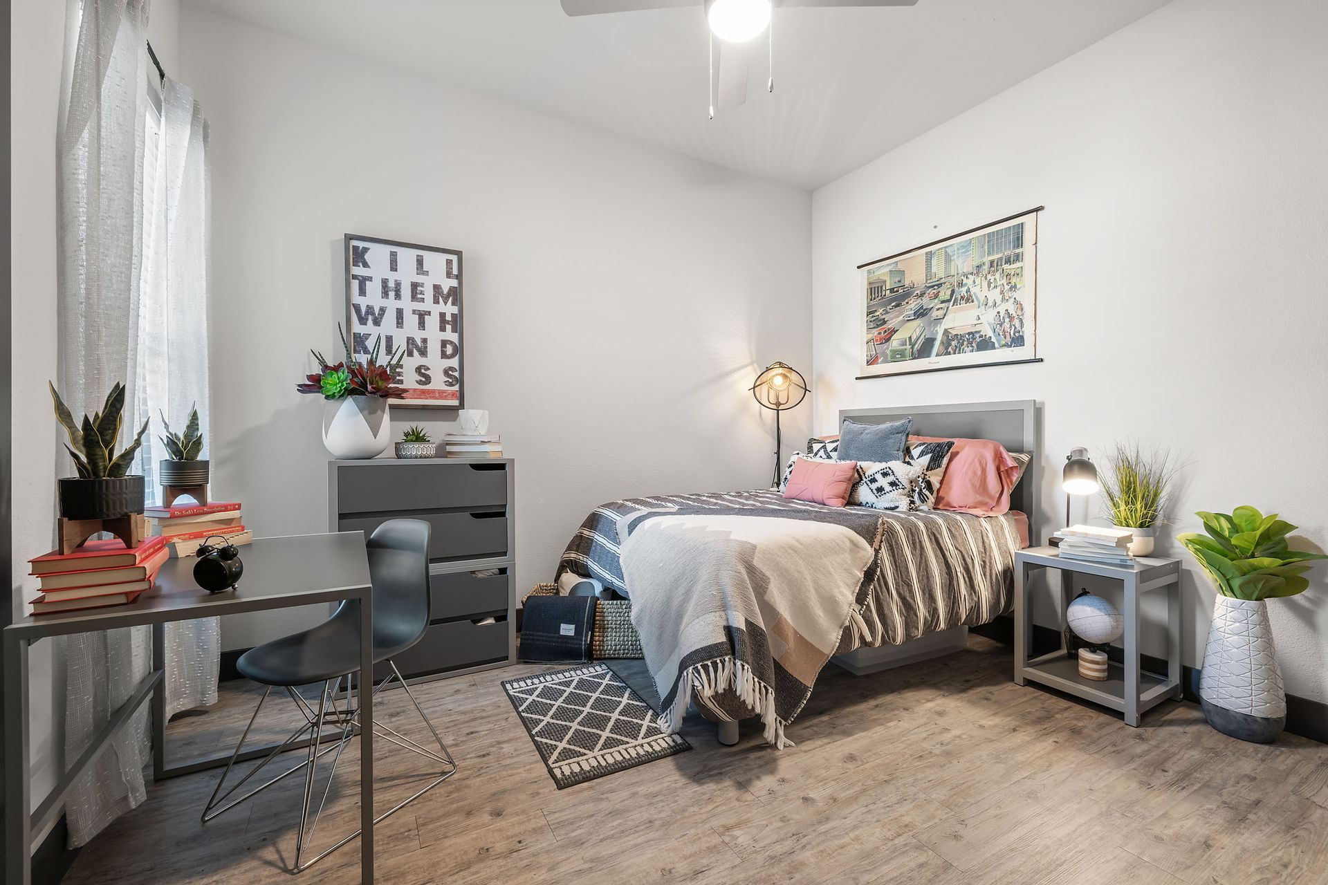 Student apartment bedroom with a bed, desk, nightstand, and a ceiling fan. at The Heights near SHSU in Huntsville, TX.