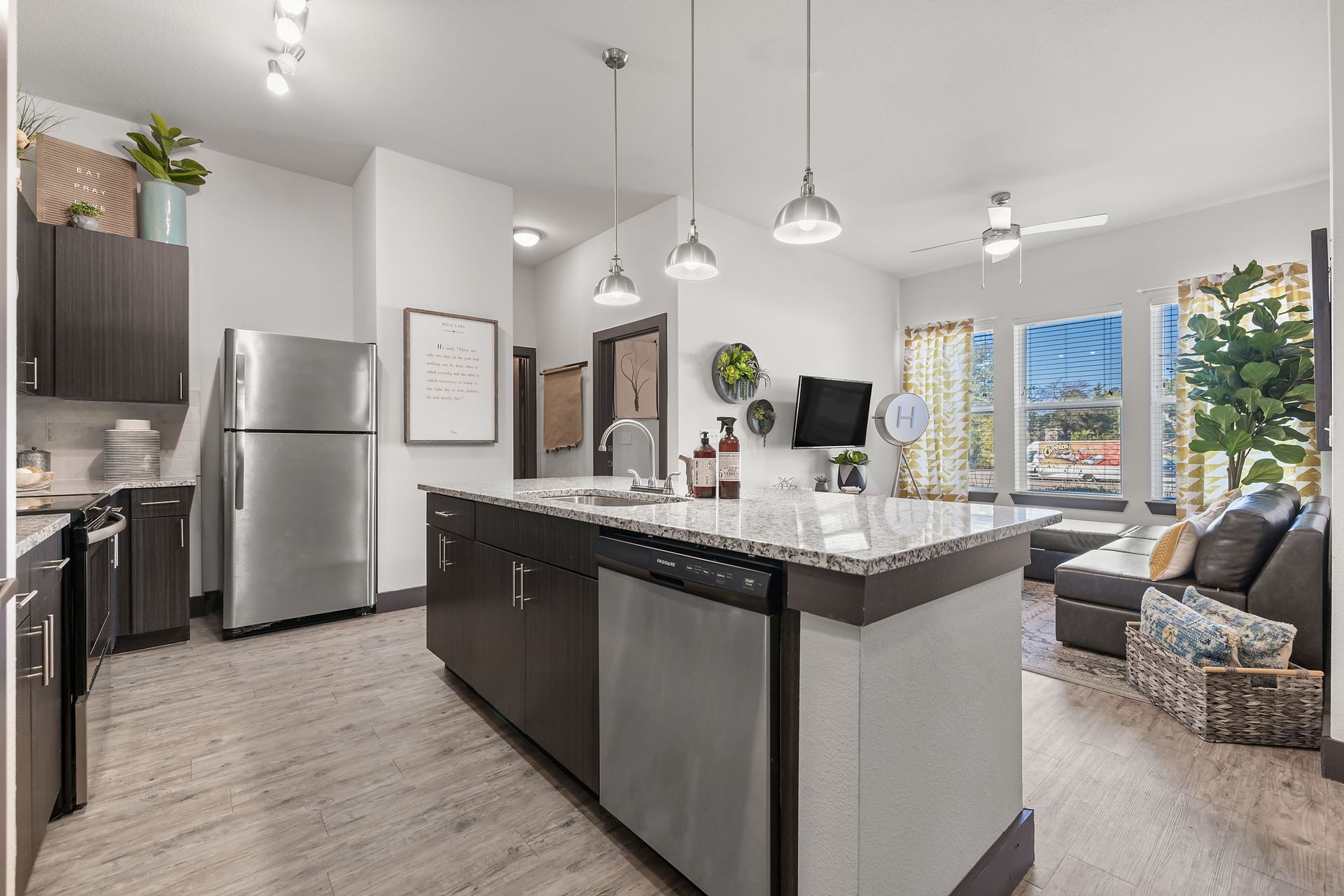 Open-concept floor plan kitchen with stainless steel appliances and a large island in the middle at The Heights offers student apartments for rent near SHSU in Huntsville, TX.