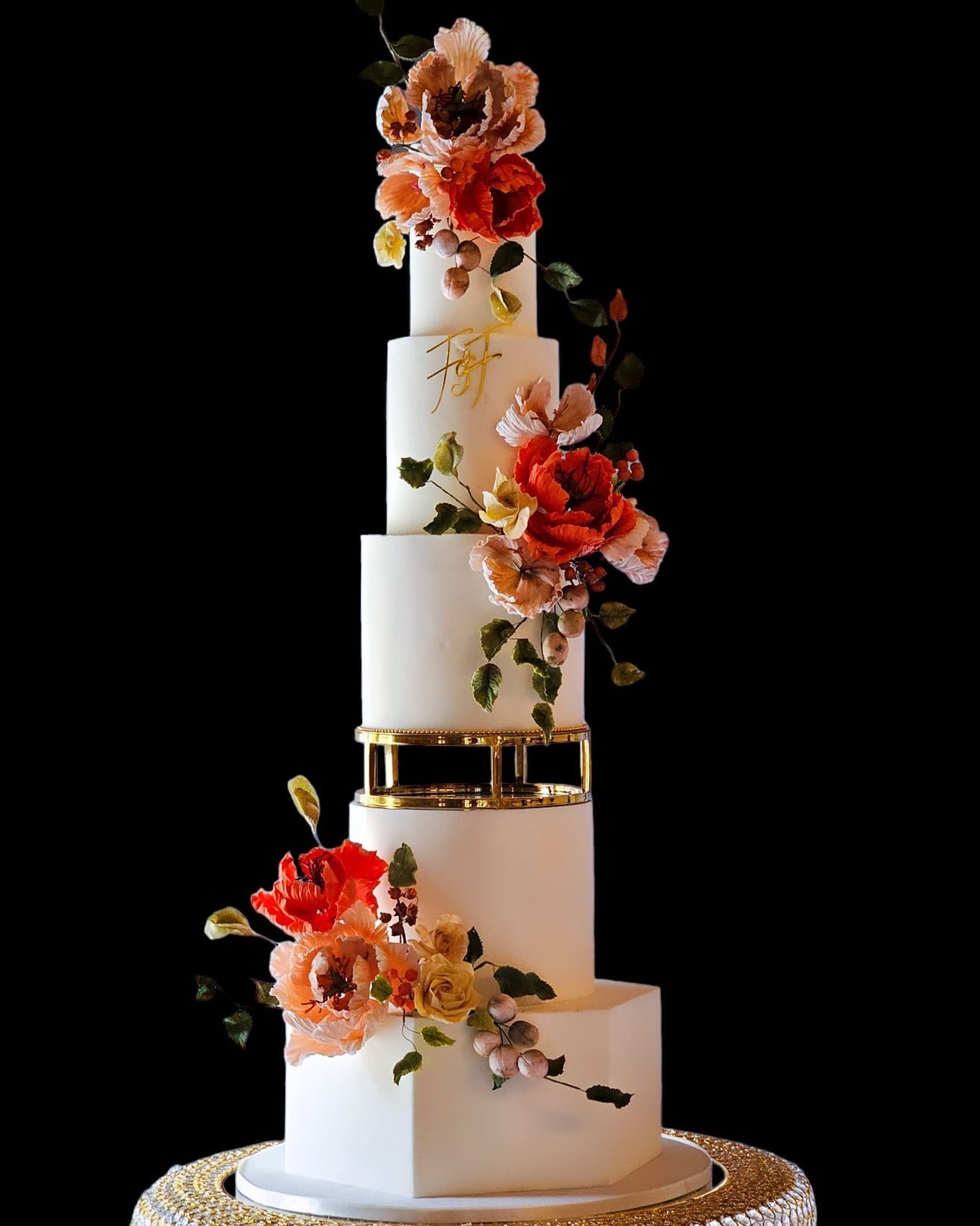 Elegant five-tiered white cake decorated with orange and pink flowers, gold accents, 