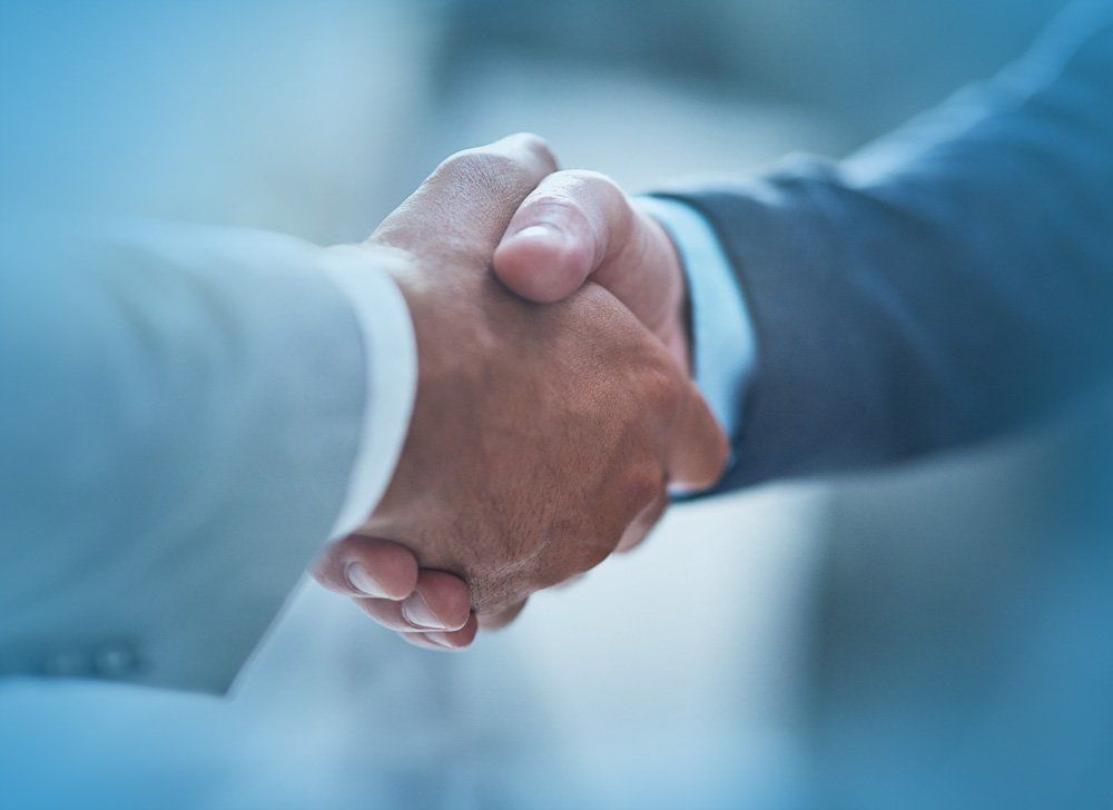 A close up of two men shaking hands.