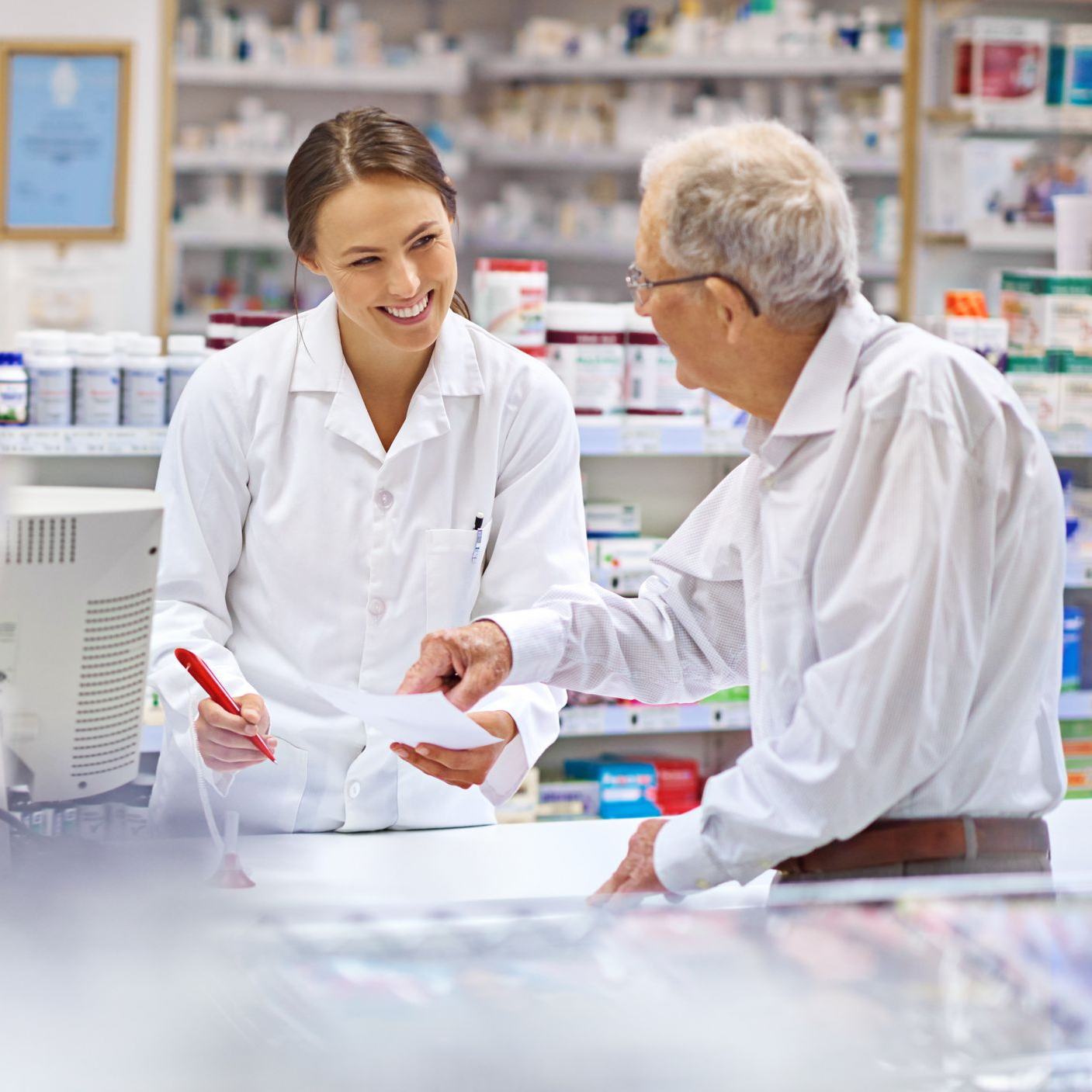 A female pharmacist is smiling while talking to a patient.