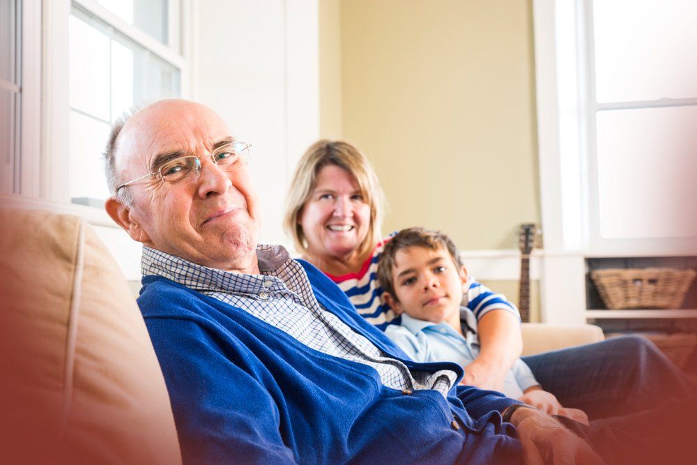 A family is sitting on a couch in a living room.