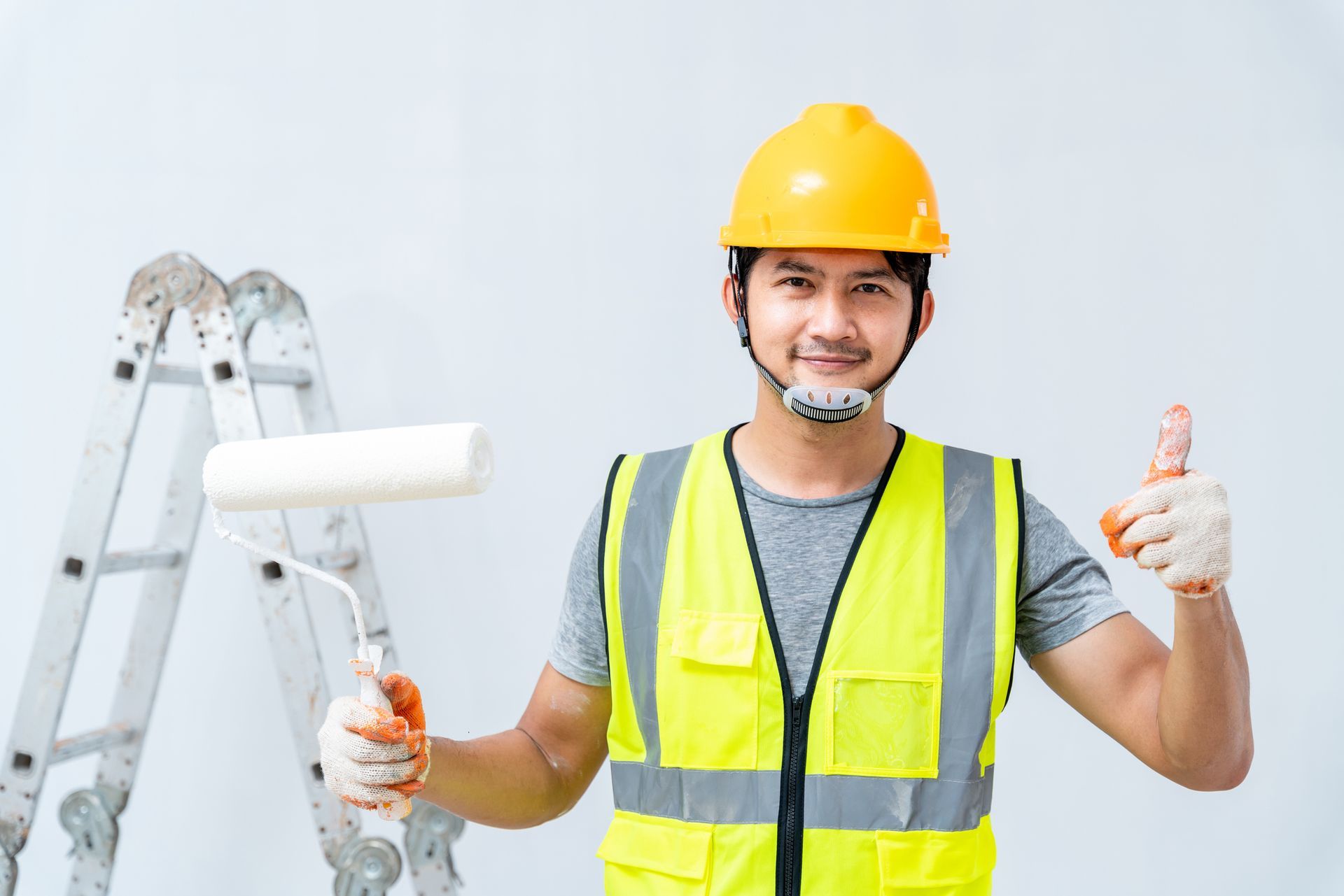 Interior painter with a roller brush working on home renovation and wall updates.