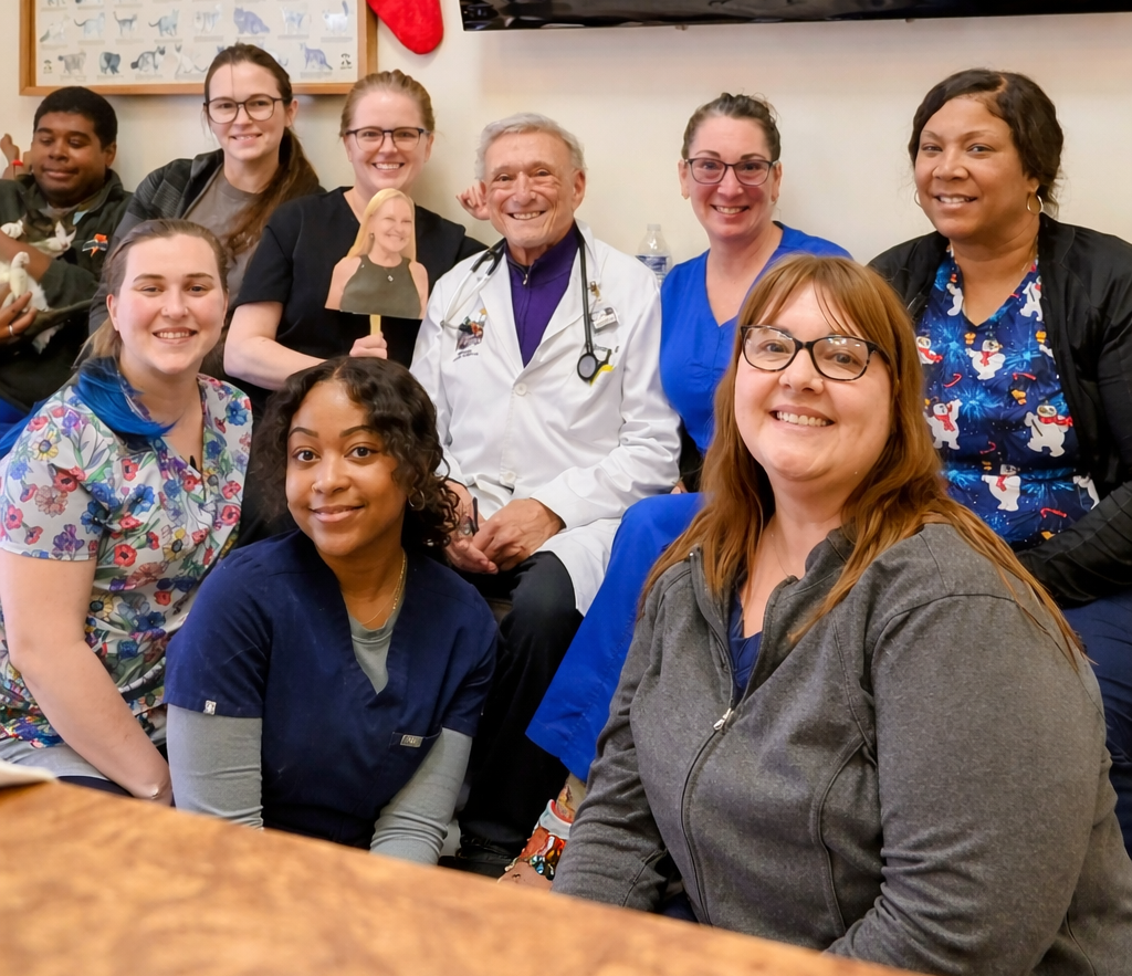 Two doctors are posing for a picture in front of a zoo poster