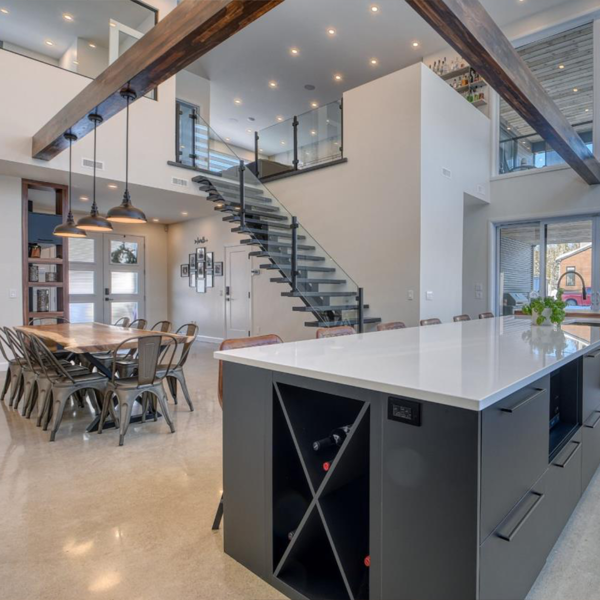 Une cuisine avec un grand îlot et un escalier