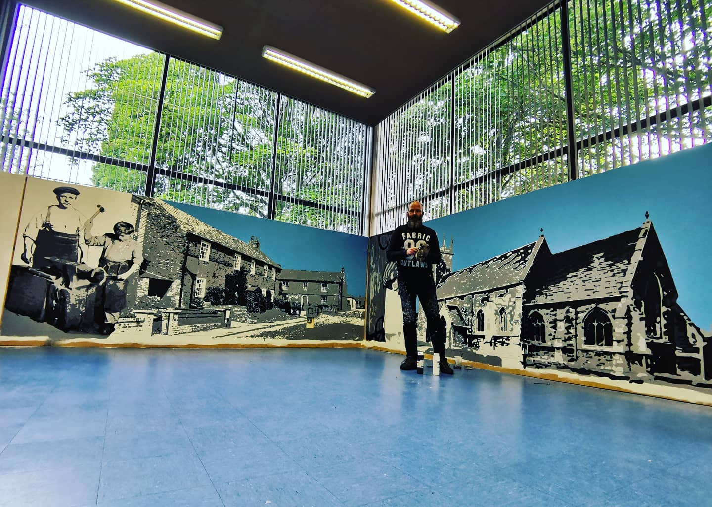 A man is standing in a room with a large mural on the wall