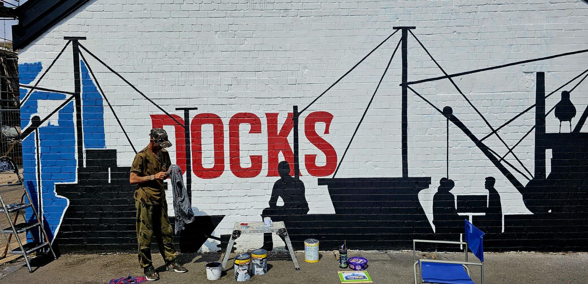 A man is standing in front of a wall that says ' dock ' on it