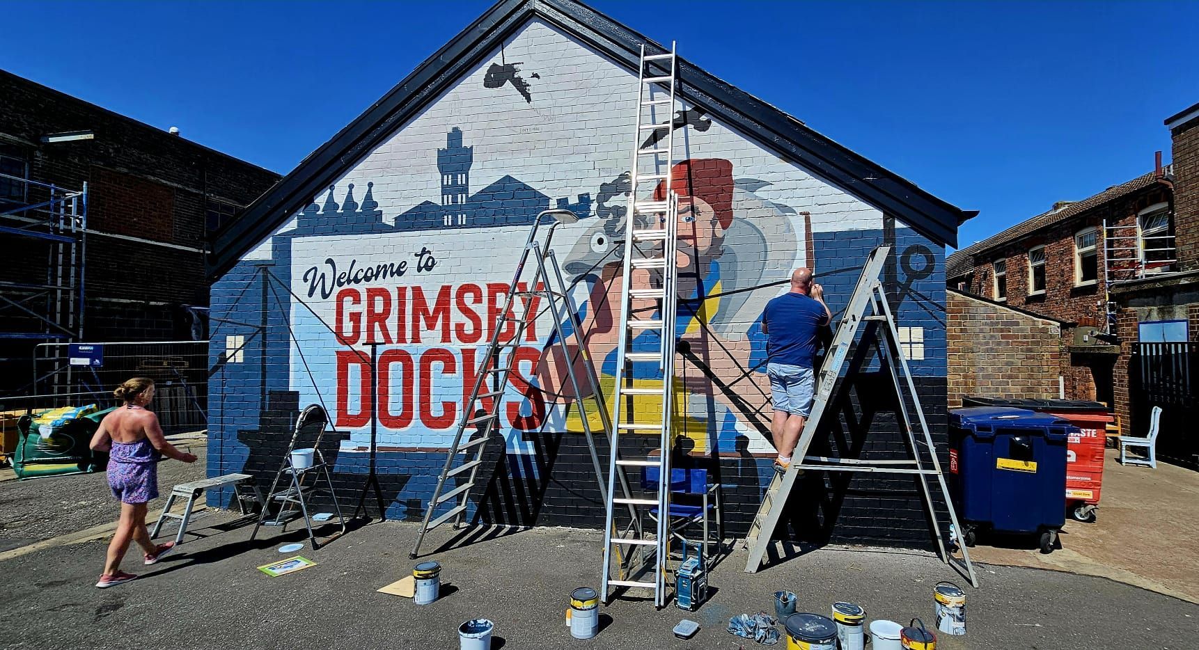 A group of people are painting a mural on the side of a building.