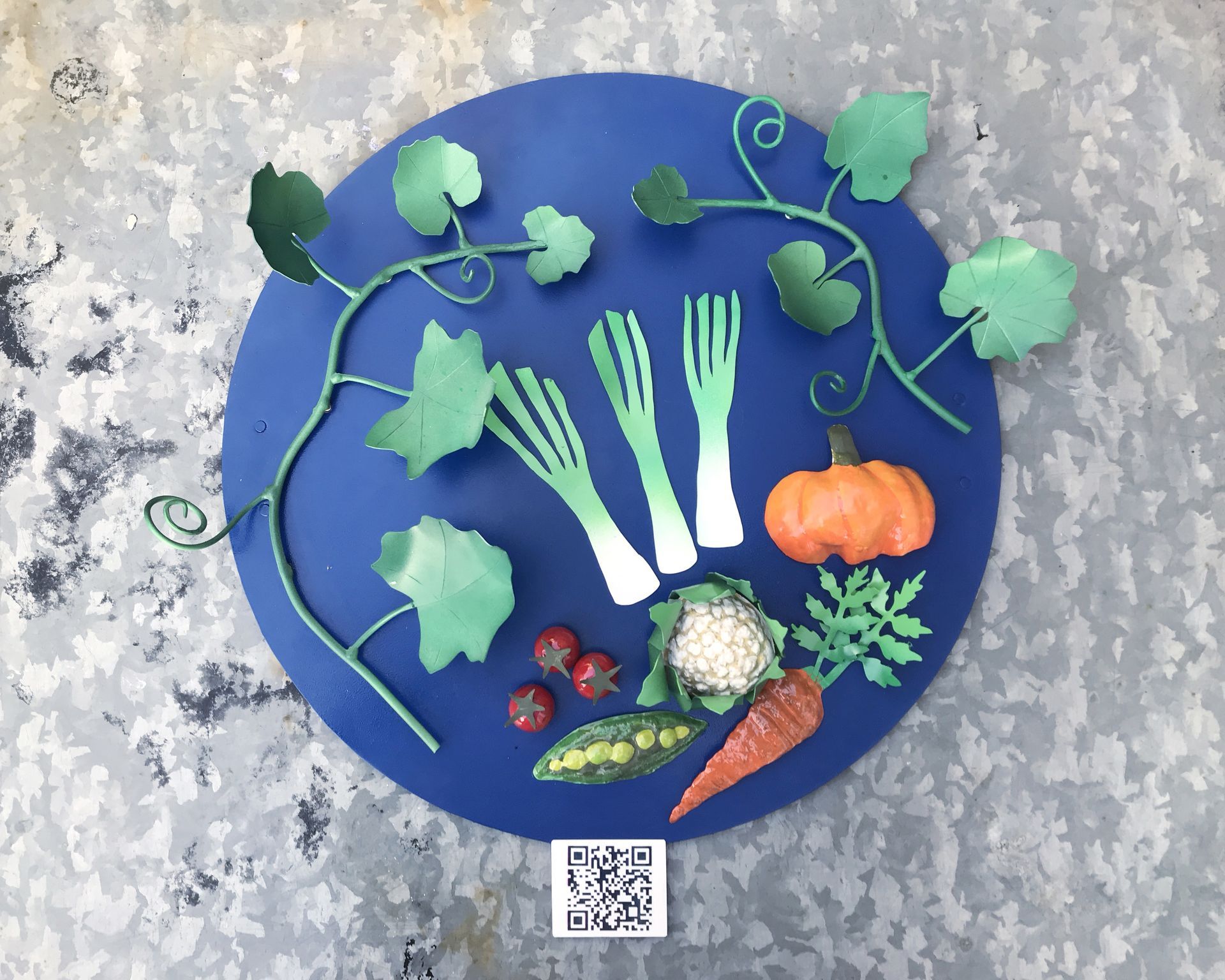 A blue plate with vegetables on it and a qr code