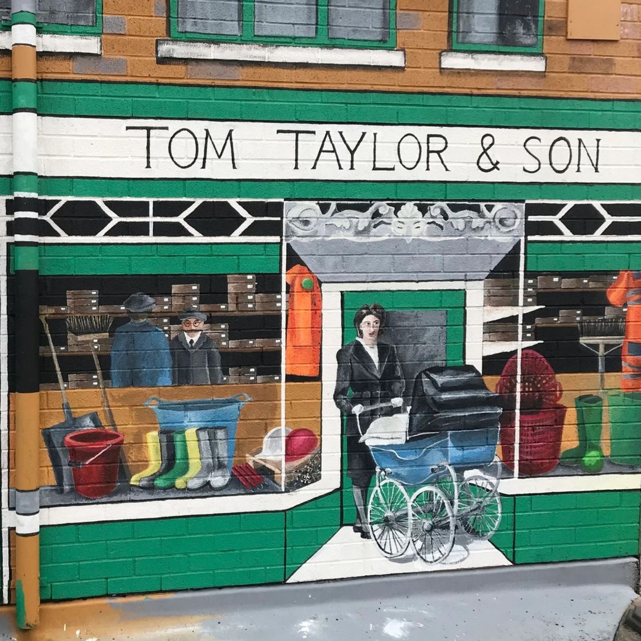 A mural on the side of a building that says tom taylor & son