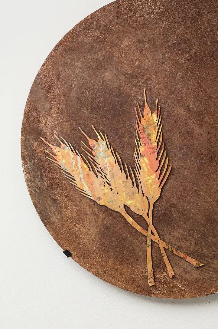 A close up of a brown plate with two wheat ears on it.