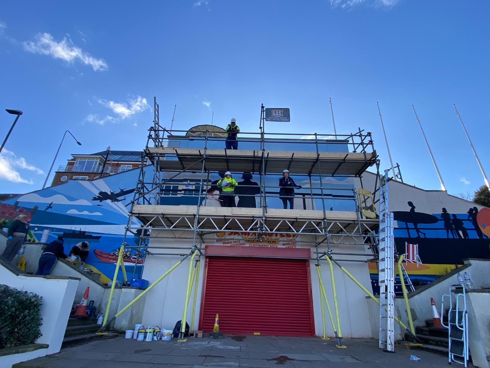 A group of people are working on a building with scaffolding.