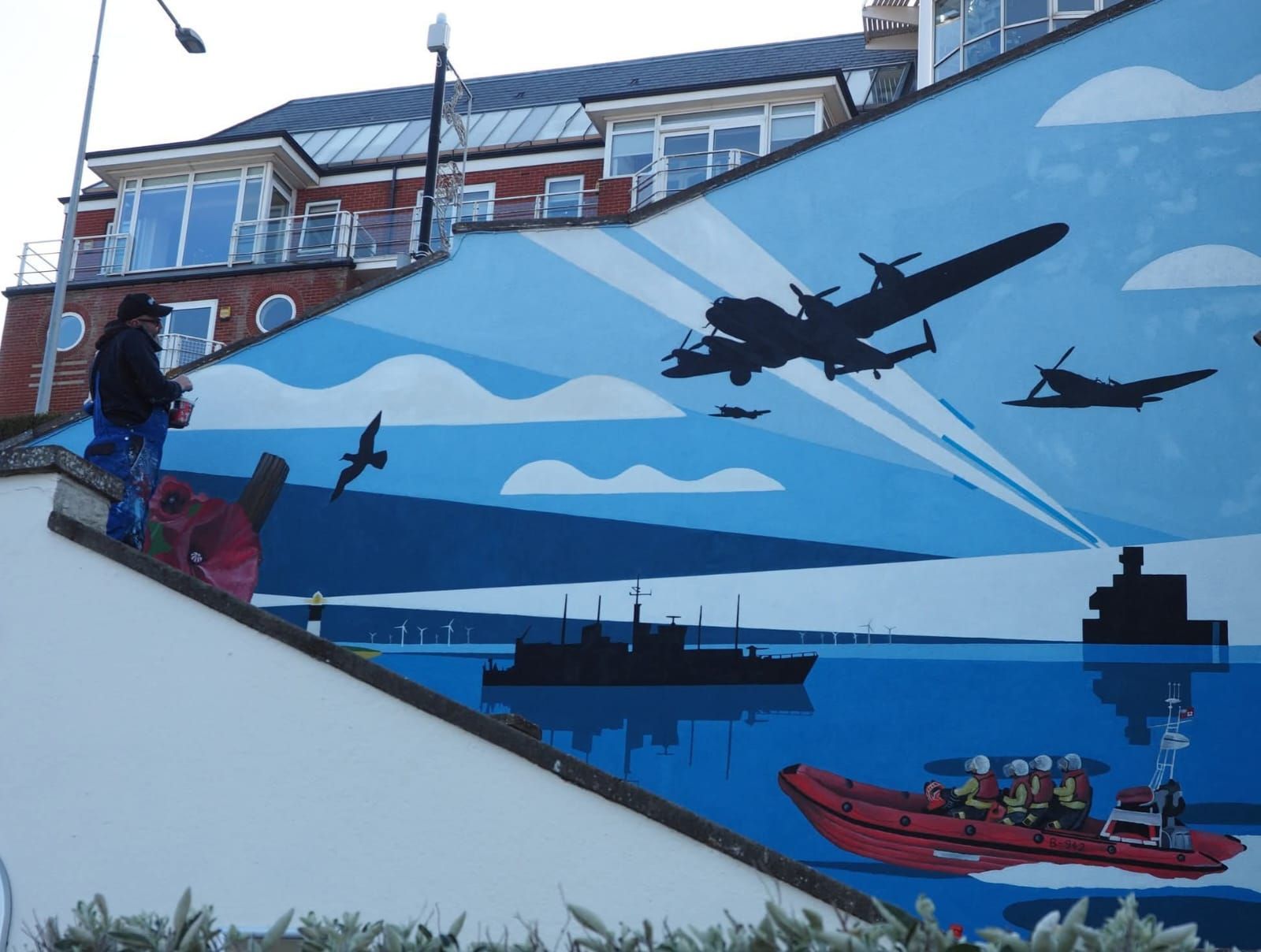 A staircase with a painting of planes and boats on it