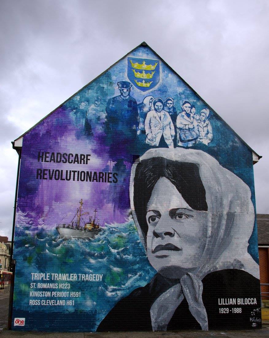 A mural on the side of a building shows a woman wearing a headscarf.