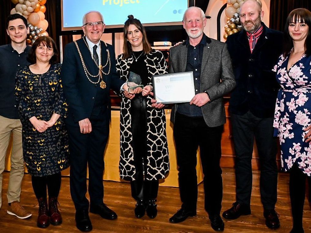 A group of people standing next to each other holding a certificate.