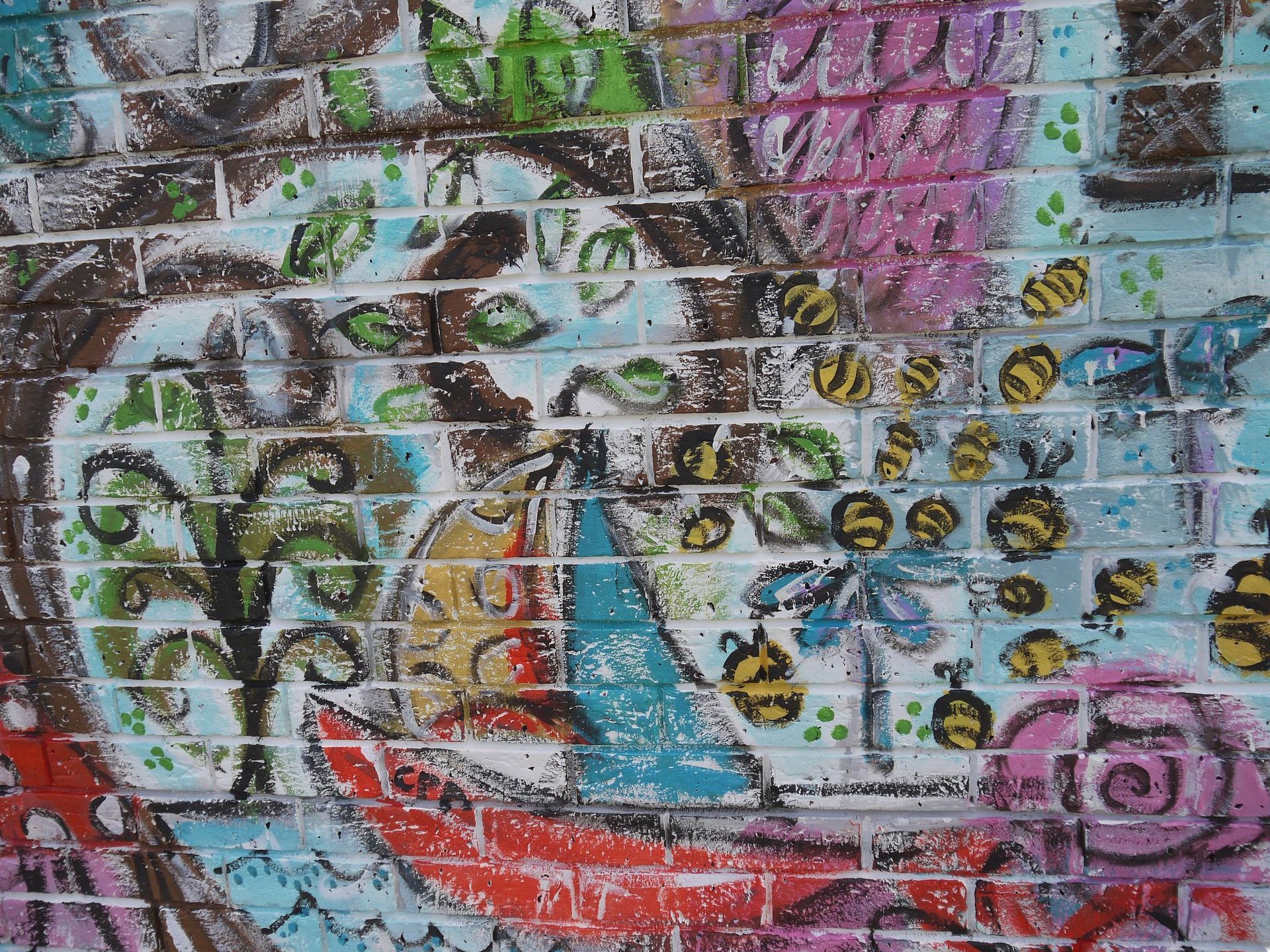 A brick wall with a lot of graffiti on it