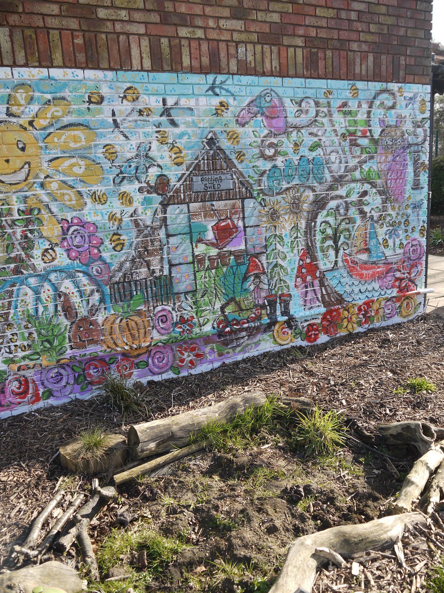 There is a large mural on the side of a brick building.