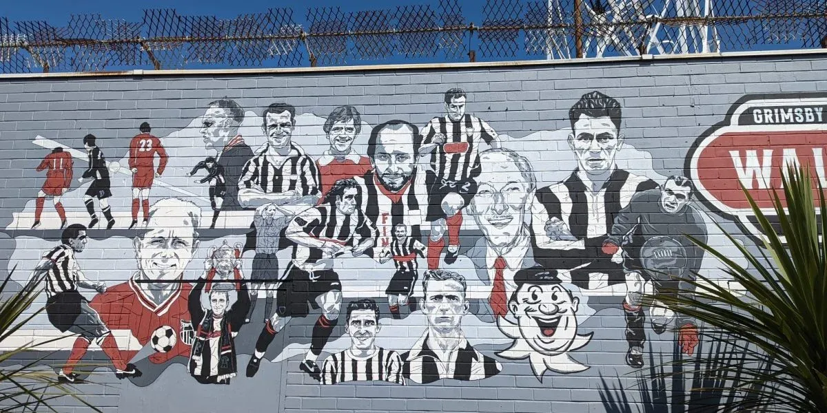 A mural of soccer players on a brick wall