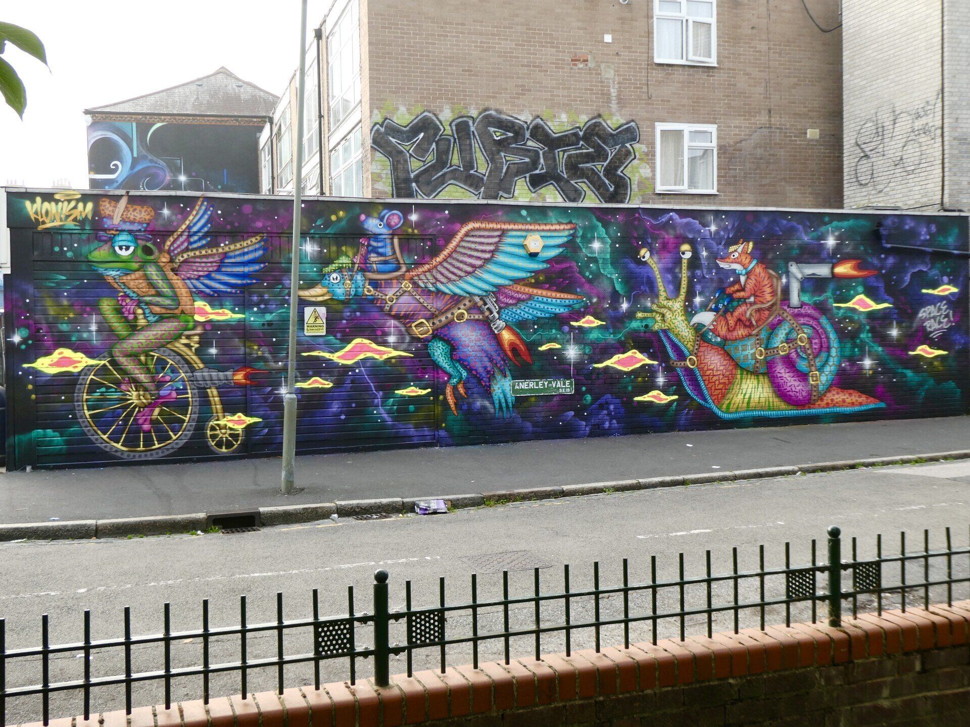A large mural on the side of a building with graffiti on it