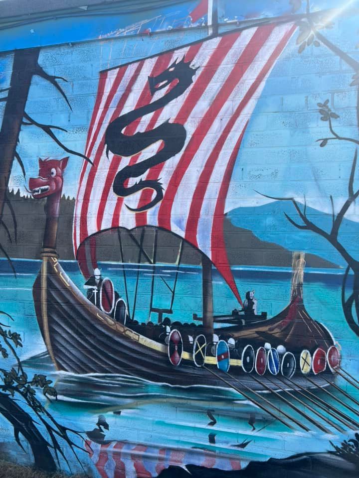 A painting of a viking ship with a dragon on the sail
