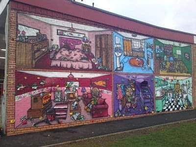 There is a large mural on the side of a building.