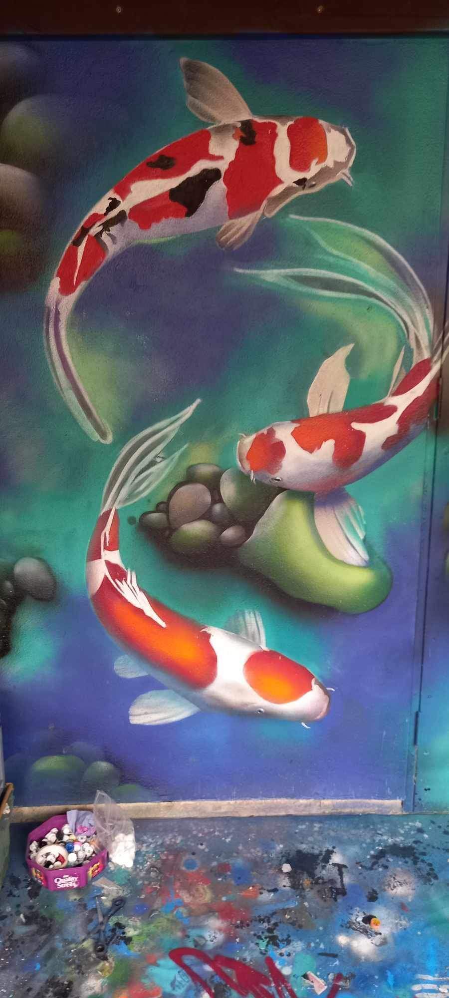A painting of three koi fish swimming in a pond.