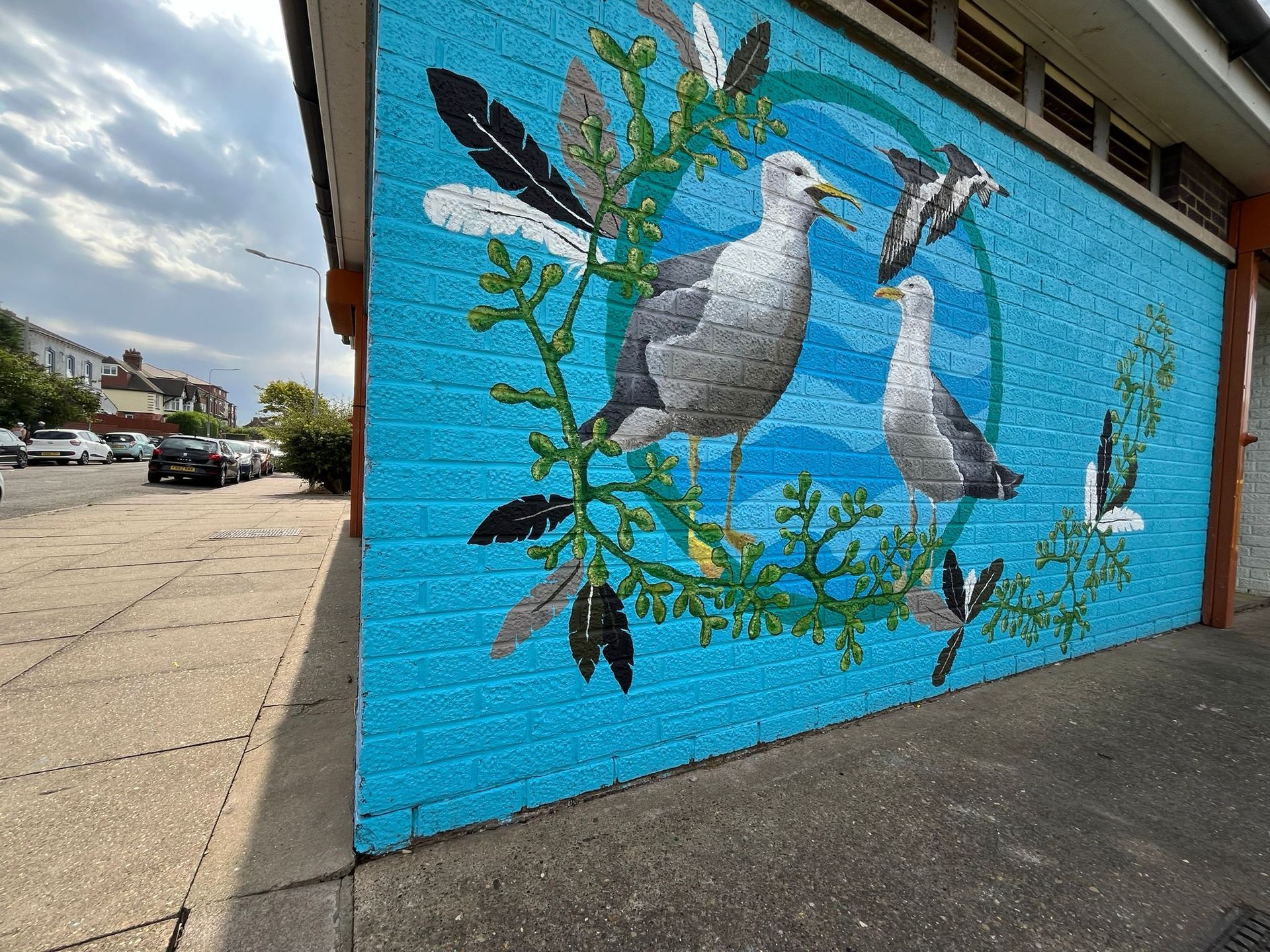 A mural of seagulls is painted on the side of a building.