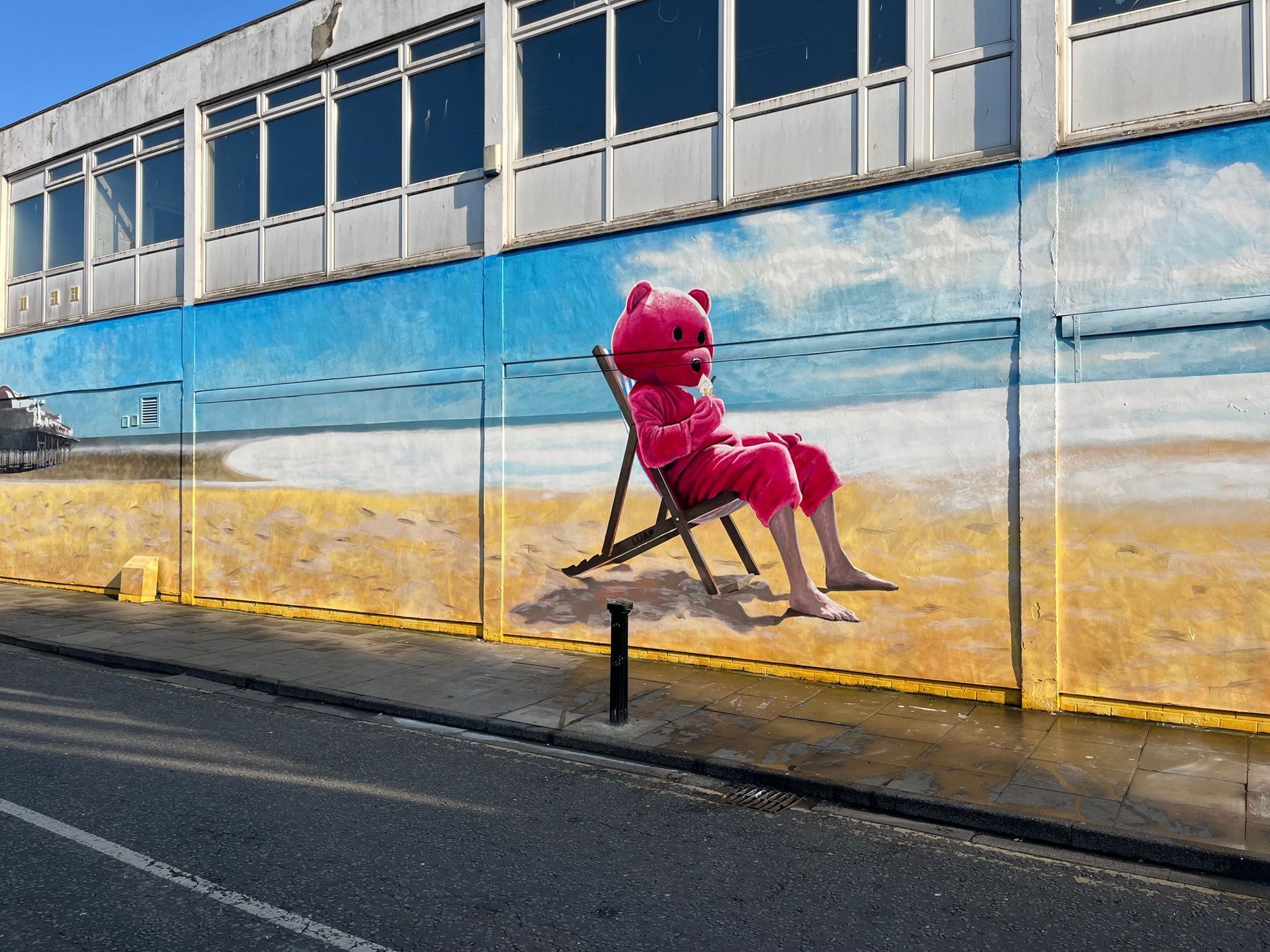 A painting of a teddy bear sitting on a beach chair