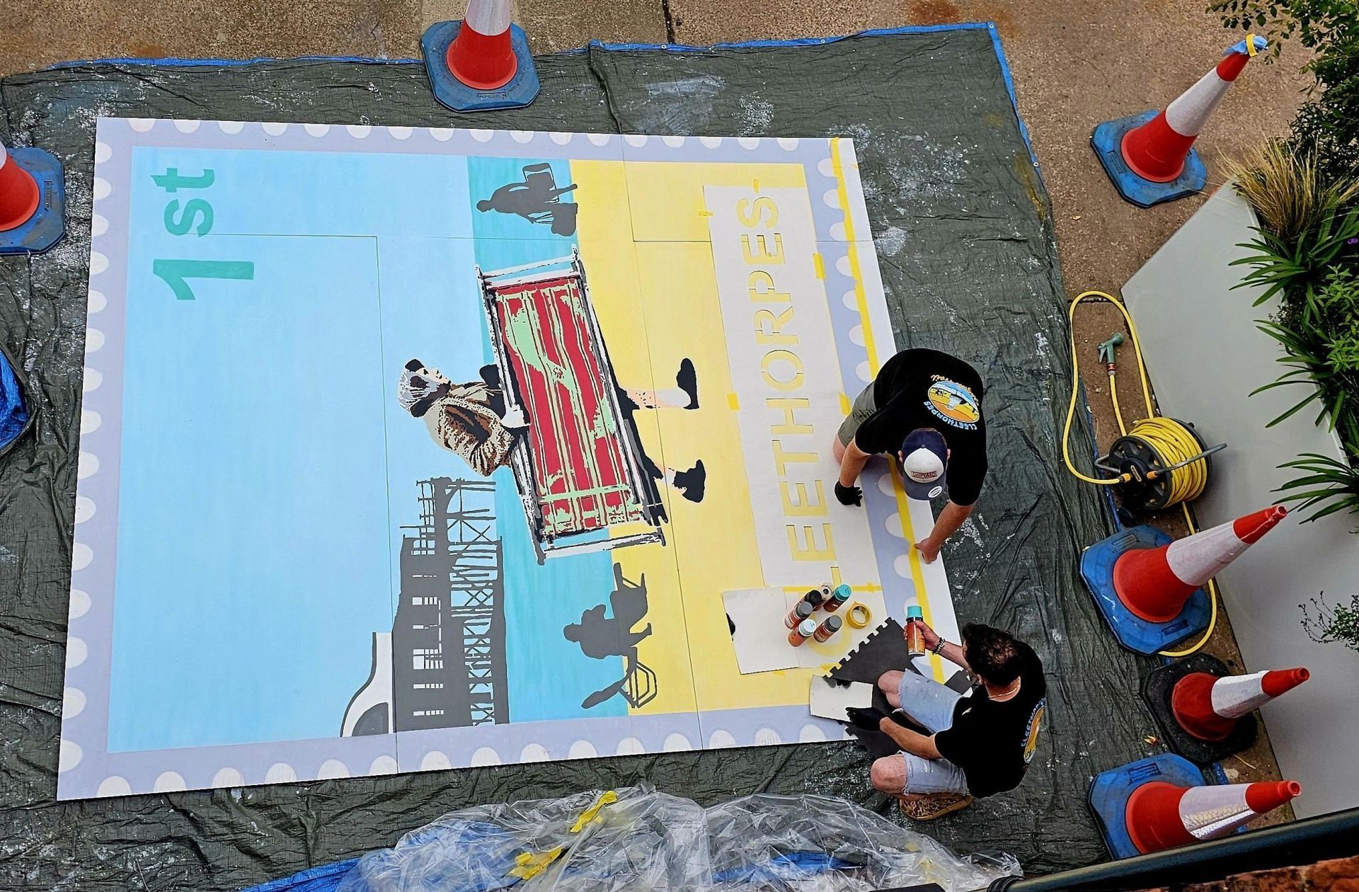 A group of people are working on a large poster that says 1st