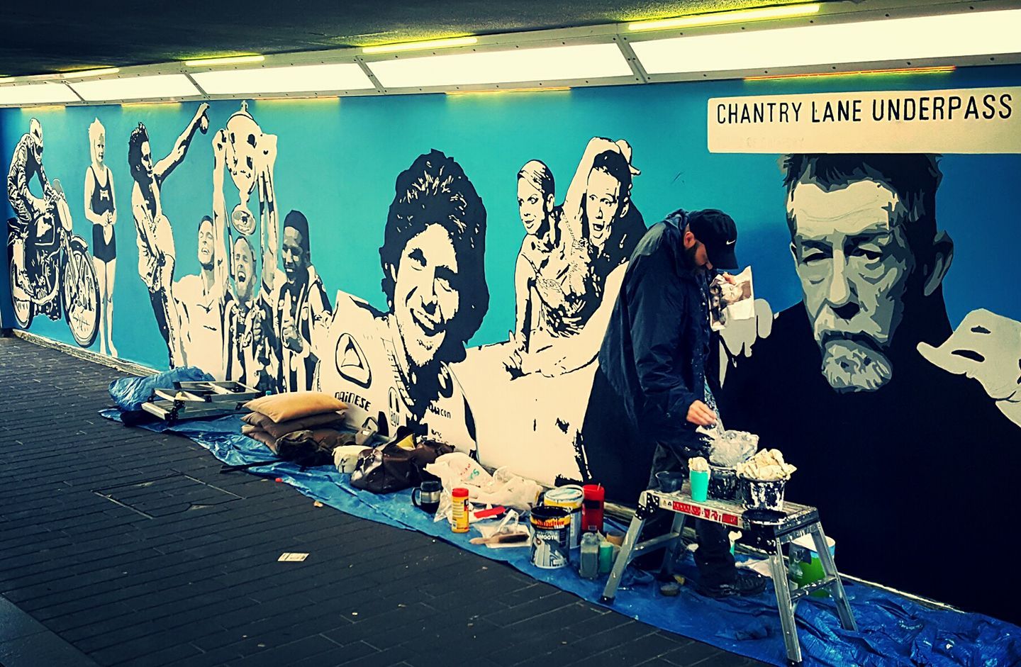 A man is painting a mural