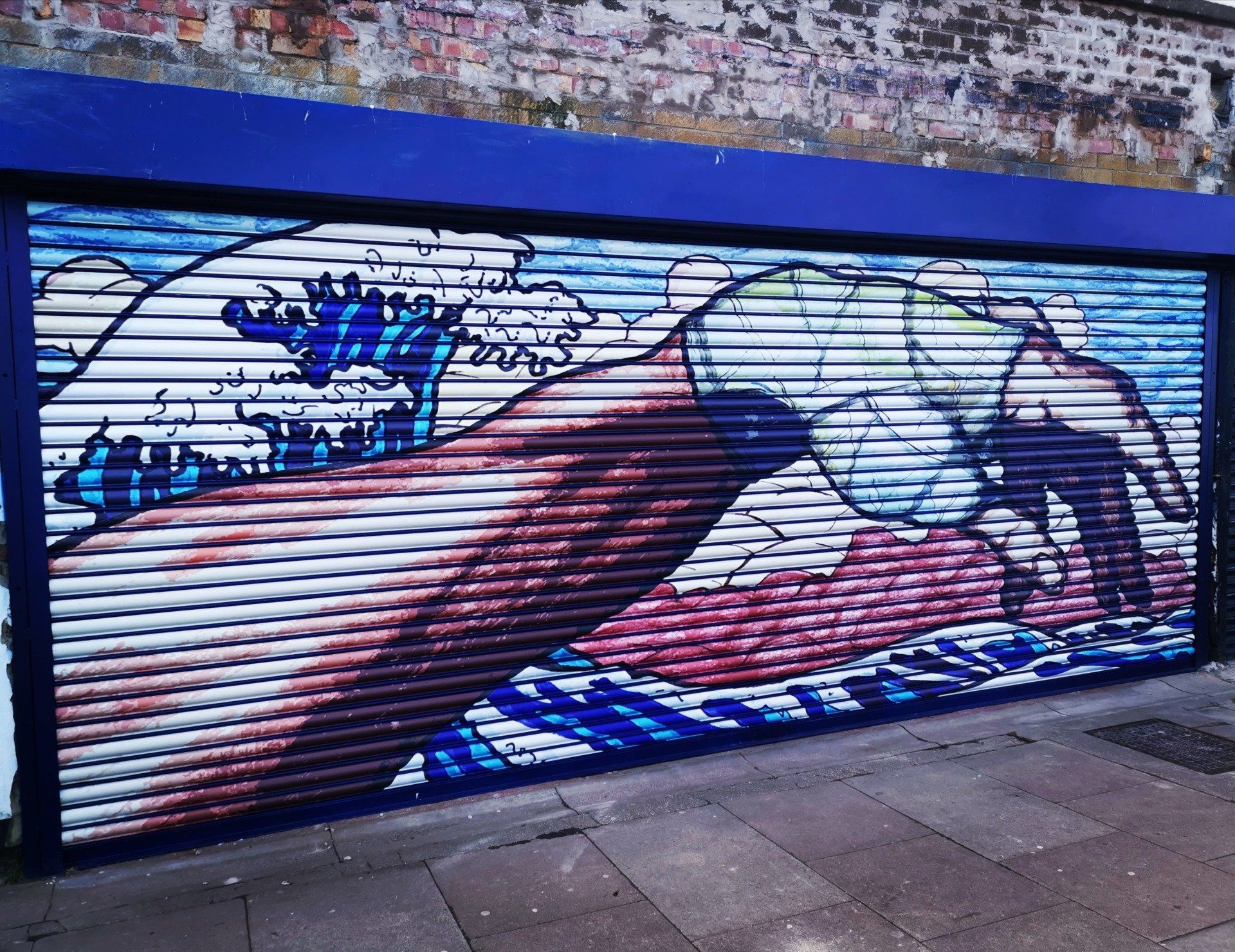 A painting of a hand reaching out towards the ocean