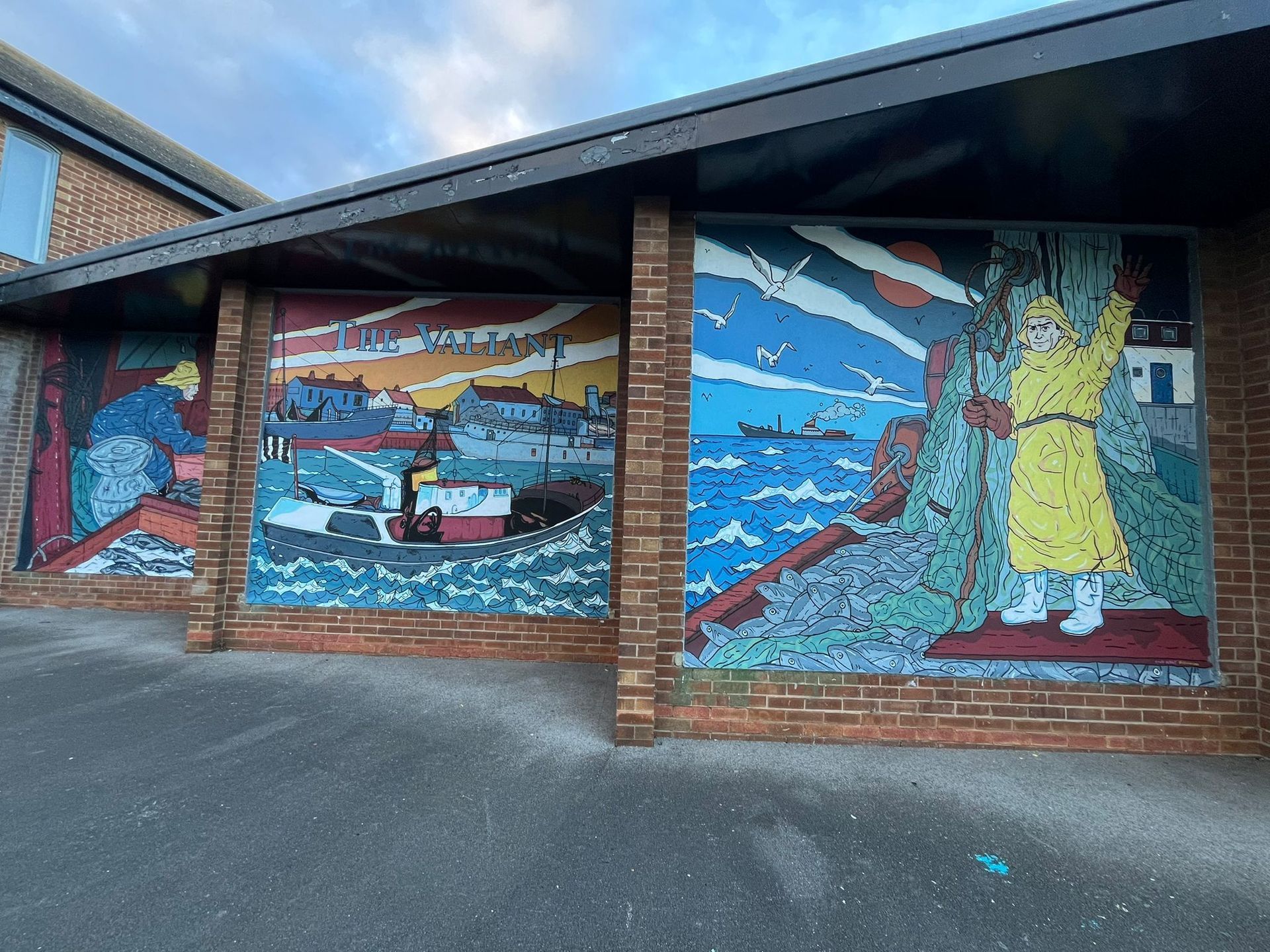 A brick building with a mural on the side of it