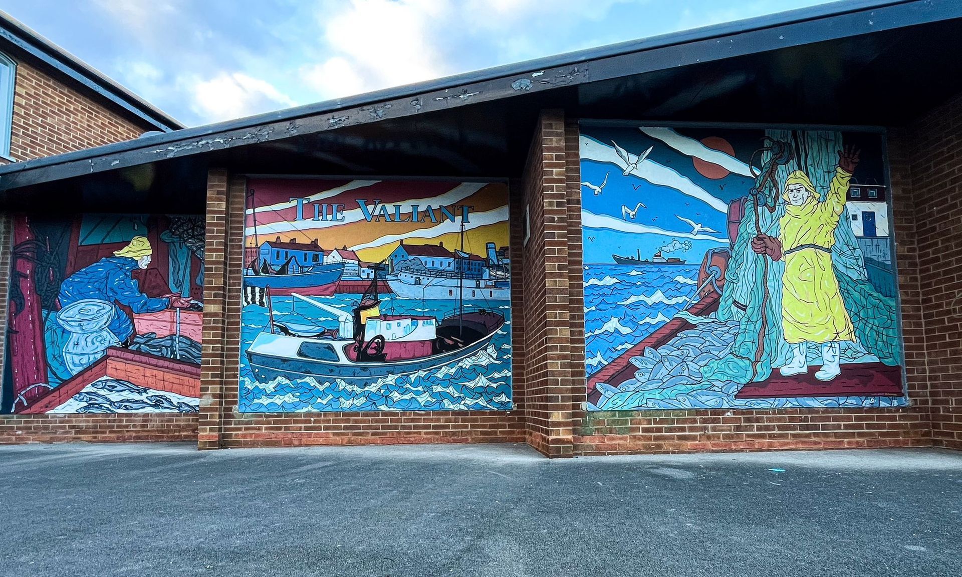 A brick building with a mural on the side of it