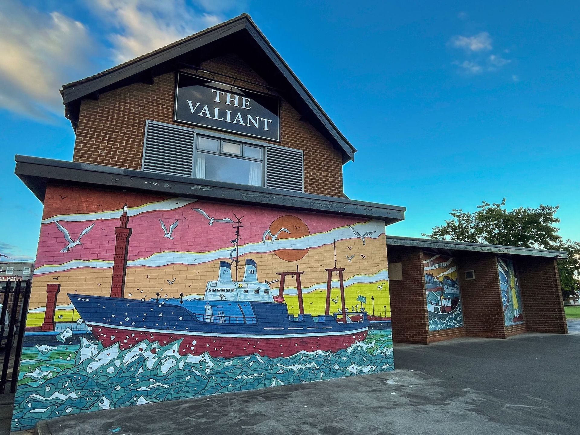 A building with a mural on the side of it that says the valiant