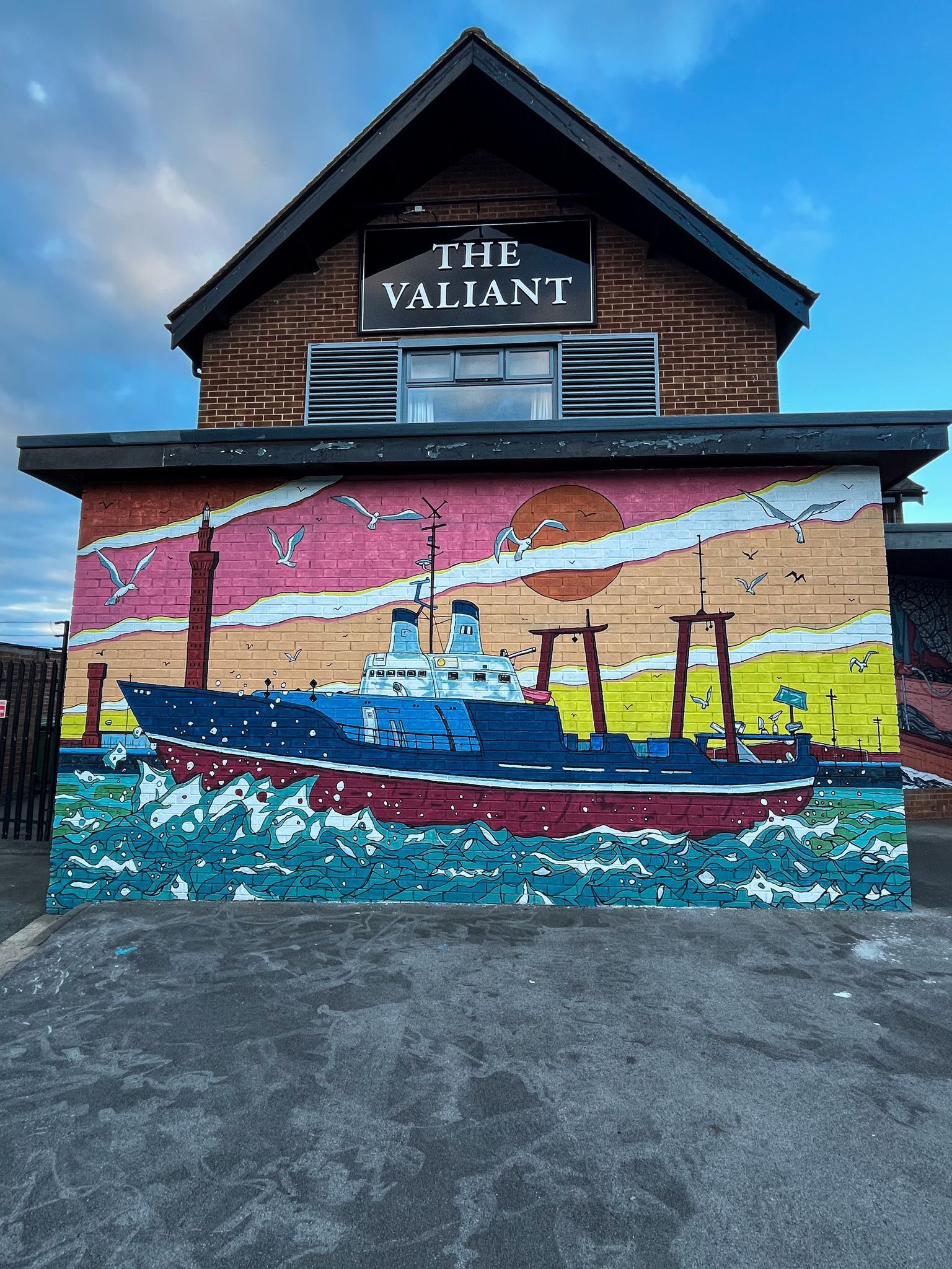 A large mural on the side of a building that says the valiant