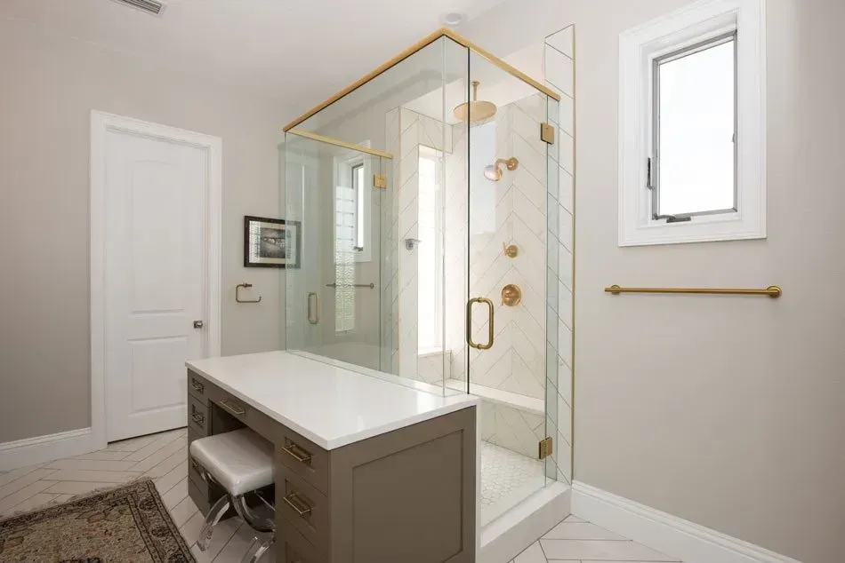 A bathroom with a walk in shower and a vanity.