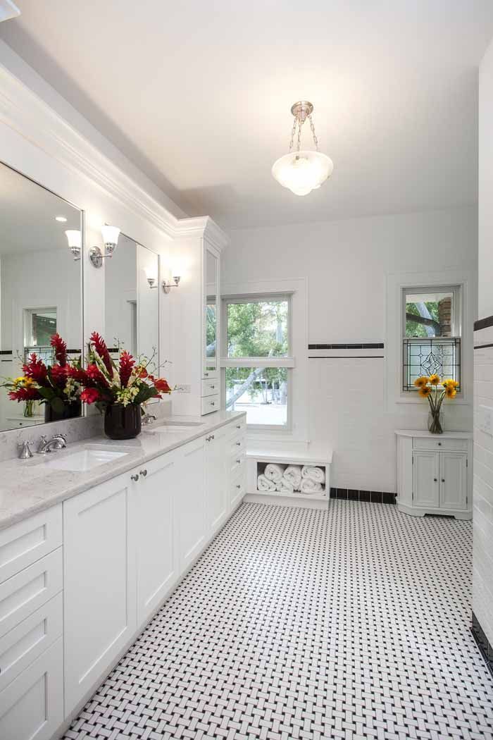 A bathroom with a black and white tile floor and two sinks.