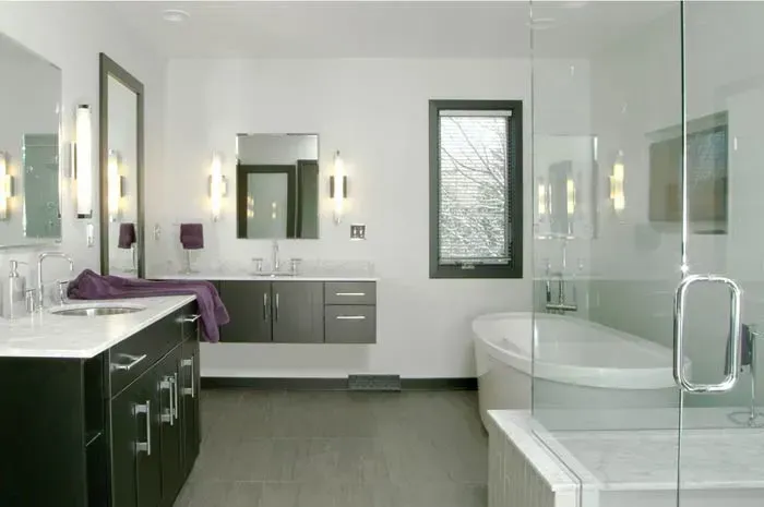 A bathroom with two sinks and a tub with a glass shower door