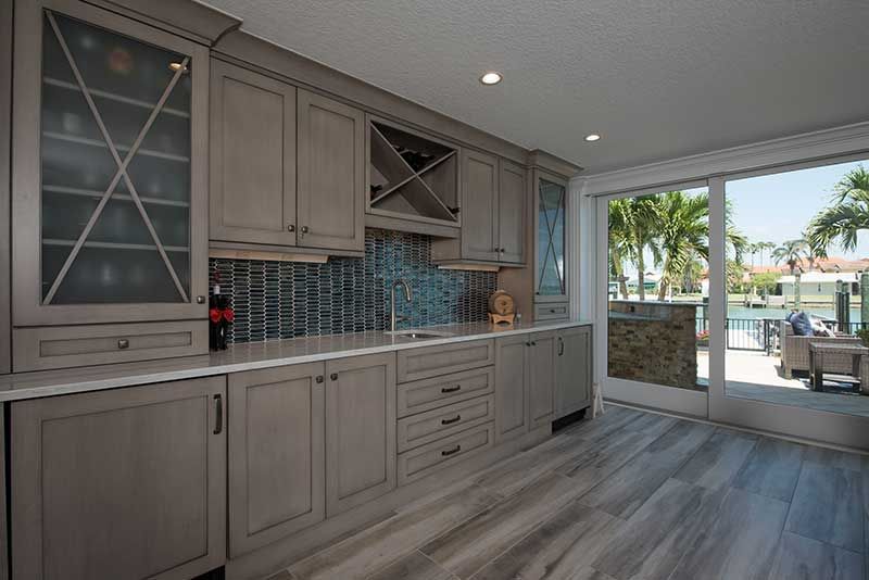 A kitchen with a lot of cabinets and a sliding glass door leading to a patio.