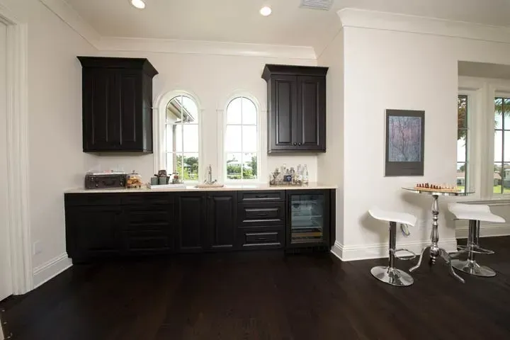 A kitchen with black cabinets and white counter tops