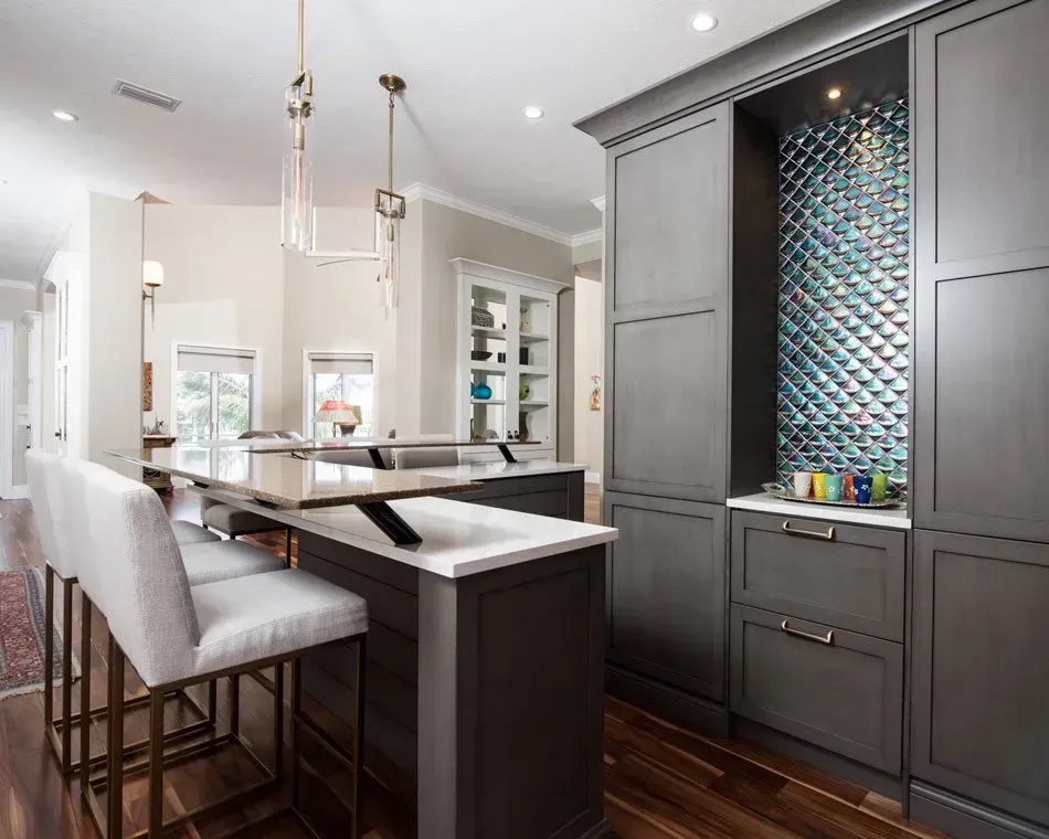 A kitchen with a large island , stools and a bar.