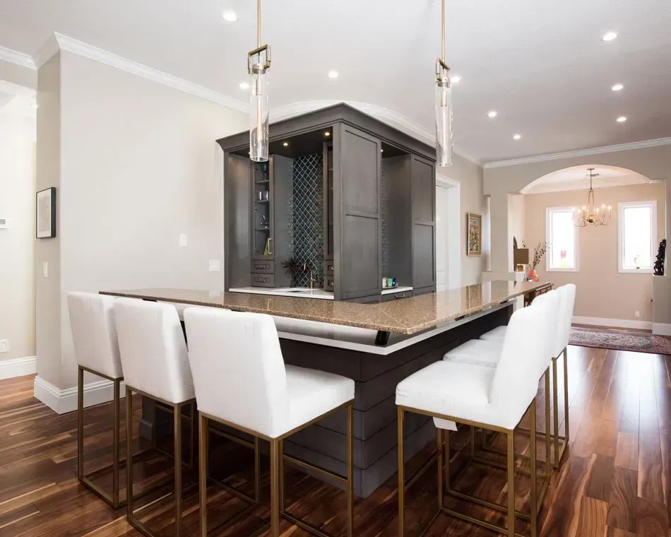 A kitchen with a bar and chairs in it.