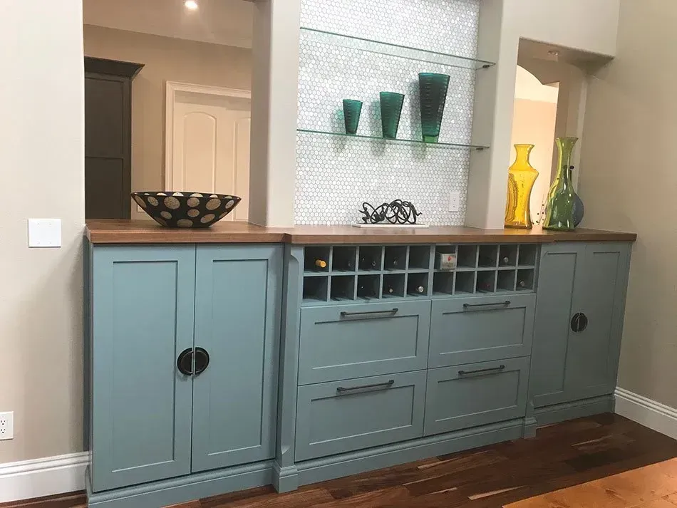 A living room with blue cabinets and a wine rack.