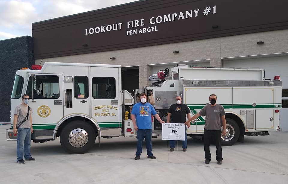 A group of men standing in front of a fire truck that says lookout fire company # 1