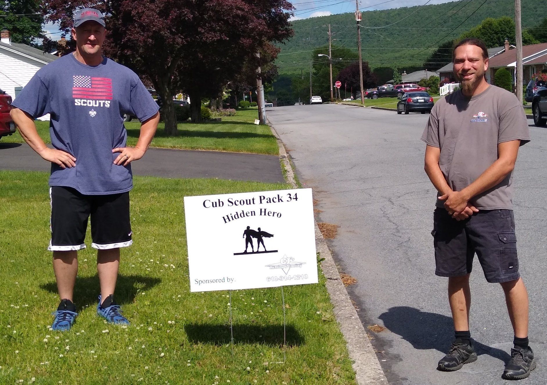 Two men standing next to a sign that says cal state pack 4