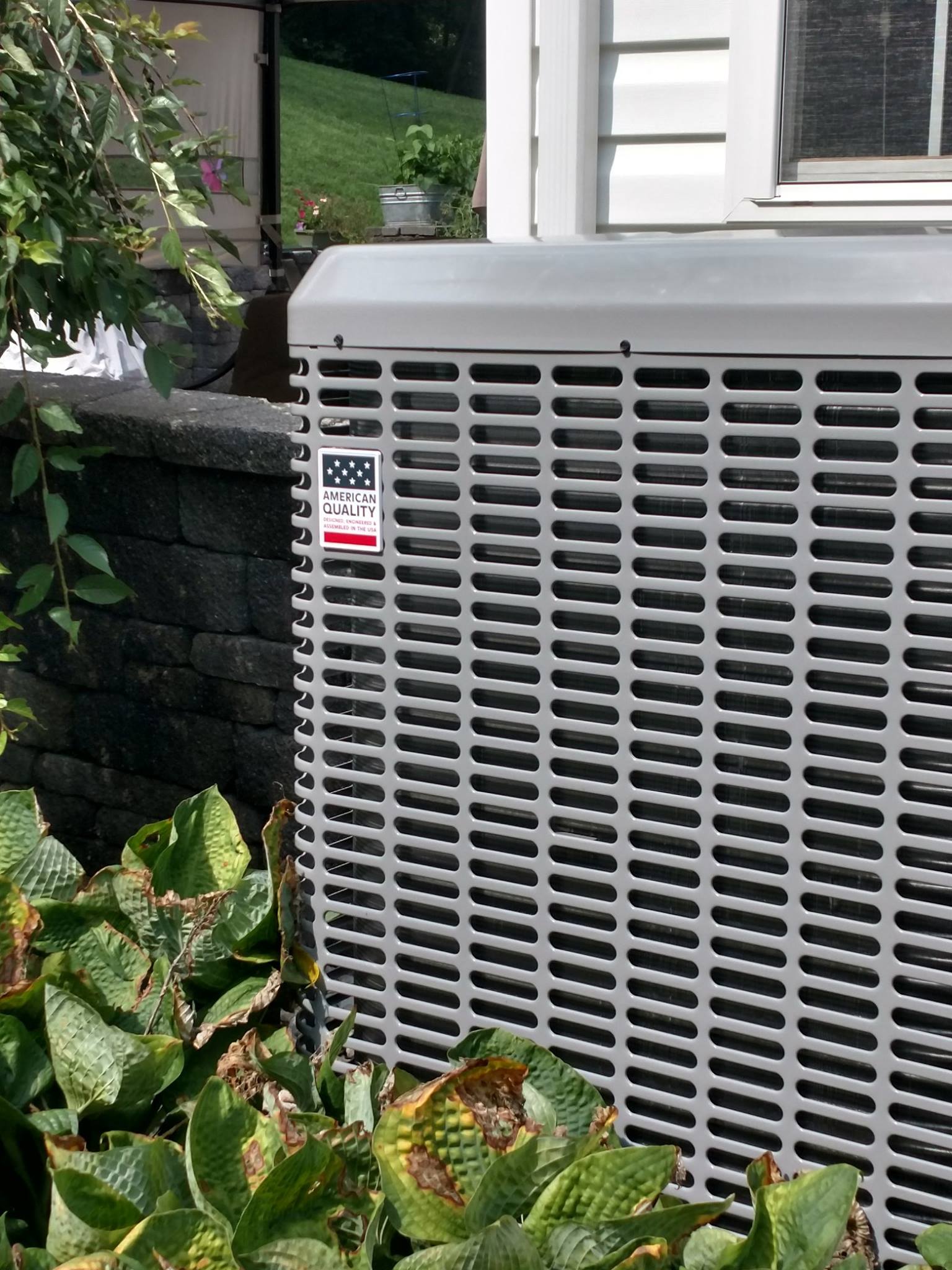 A large air conditioner is sitting on the side of a house.