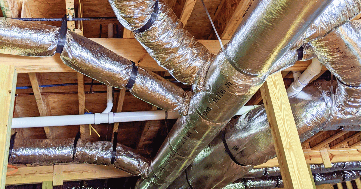 A bunch of pipes are hanging from the ceiling of a building.