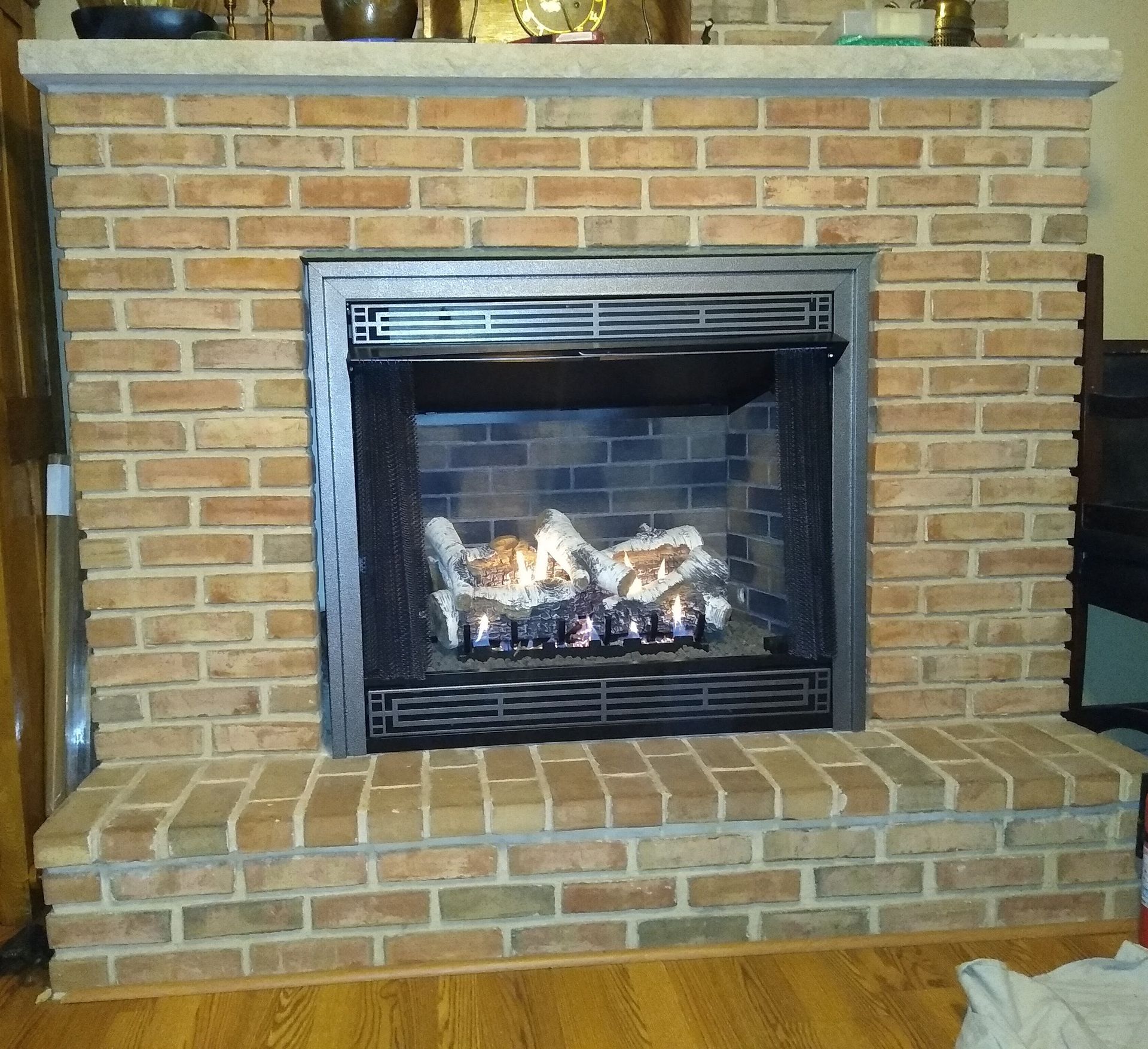 A brick fireplace with a stove inside of it